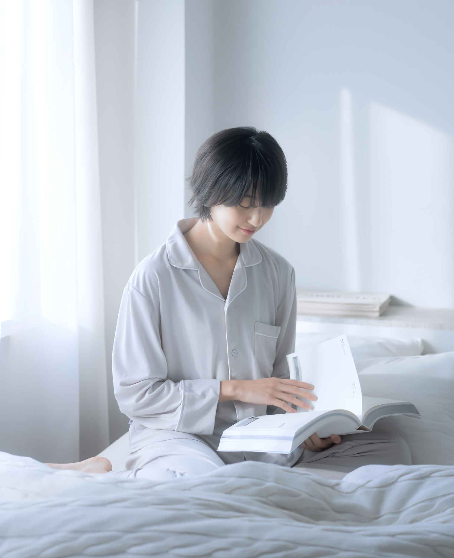 ベッドに座って本を読む女性
